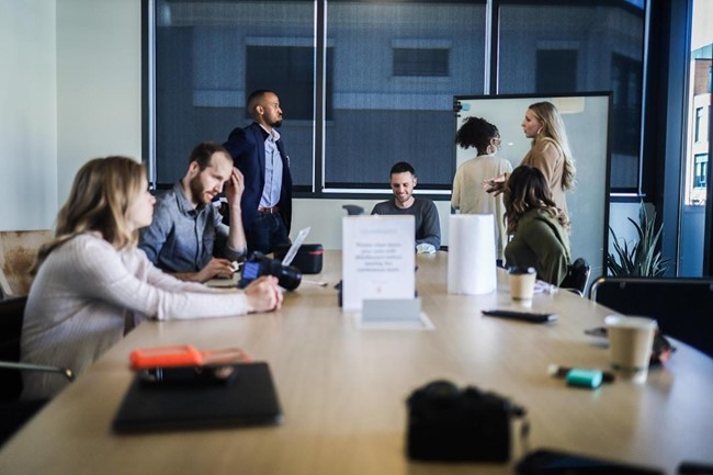 A group of professionals gathered around the table to discuss what is revenue leakage and how to prevent it.