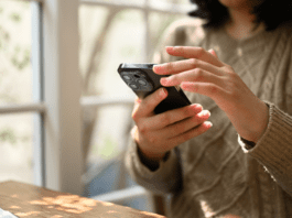Person holding a smartphone while using digital detox tools to reduce screen time