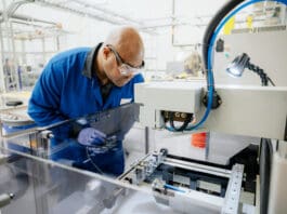 Apple rare-earth supply chain facility in the United States with workers handling magnetic materials.